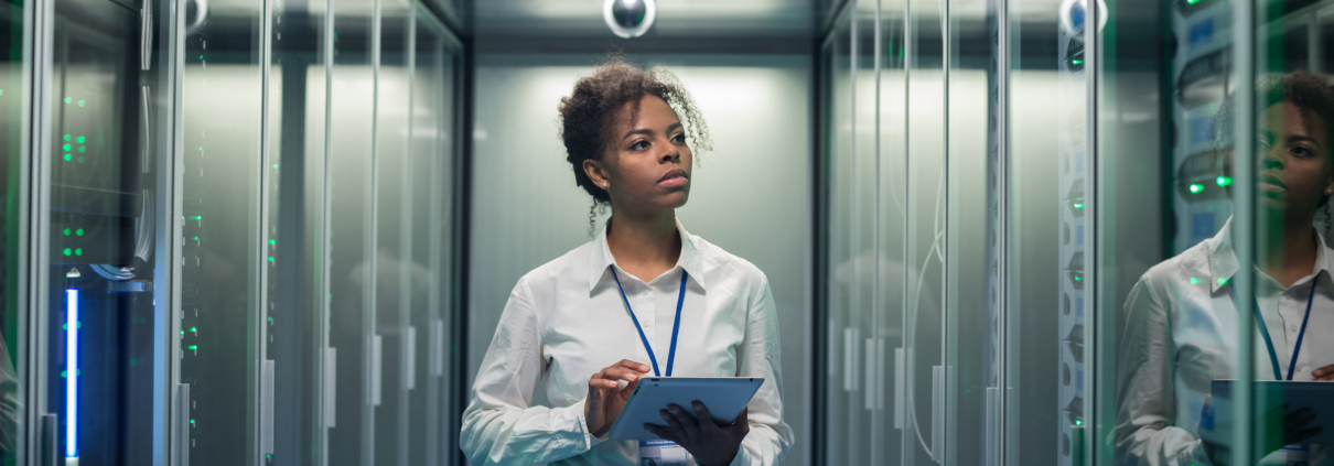 Woman with tablet reviewing transfer switch equipment in a data center